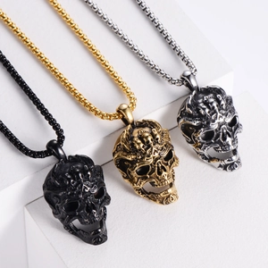 Detailed view of skull necklaces in black, gold, and silver on geometric blocks
