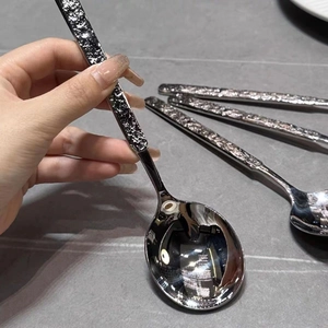 Detail of stainless steel spoon featuring a textured handle and polished mirror finish