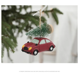Close-up of red vintage car Christmas tree ornament with snowy pine tree decor