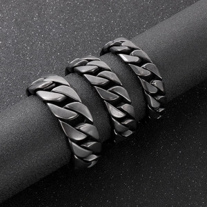 Gros plan de bagues à maillons cubains noirs mats pour hommes sur supports sombres