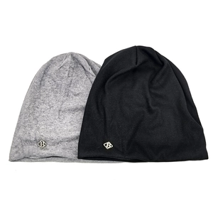 Detailed view of grey and black knitted beanies with metallic diamond B logos