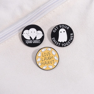 Three Halloween ghost enamel pins with funny slogans on white canvas bag fabric