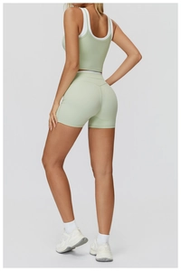 Détail du short de yoga vert menthe à taille haute avec débardeur de sport superposé