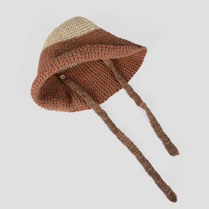 Detalle de sombrero de sol de ganchillo bicolor en beige y marrón con cintas largas