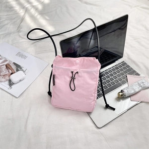 Mini borsa a tracolla rosa con coulisse su lenzuolo bianco con accessori lifestyle inclusi