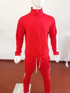 Detail of red men's tracksuit showing white side stripes on jacket and pants