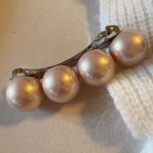 Detail of pink faux pearls on a metal spring hair clip for women's hair styling