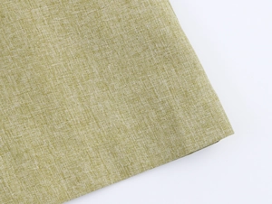 Close-up of light sage green linen fabric texture showing natural woven details