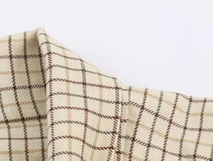 Macro view of beige plaid woven fabric texture and vintage check pattern on the collar