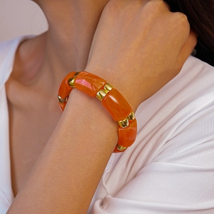 Detail of vintage geometric acrylic link bracelet with orange resin and gold metal spacers