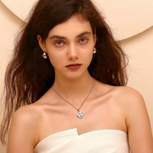 Dettaglio modella con collana quadrata in argento testurizzato e orecchini coordinati a lobo
