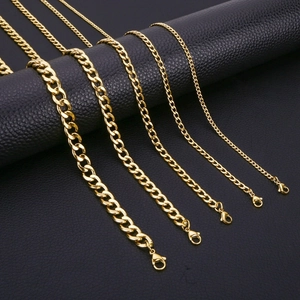Five gold stainless steel Cuban link chains in various widths on black background