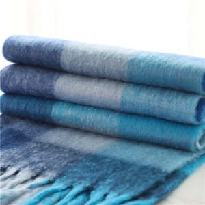 Detailed view of winter scarf showing thick knit texture and long tassel fringe