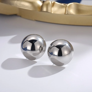 Macro shot of minimalist polished silver stainless steel spherical stud earrings set