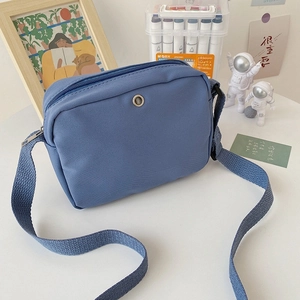Blue canvas crossbody bag with adjustable strap in a minimalist rectangular design
