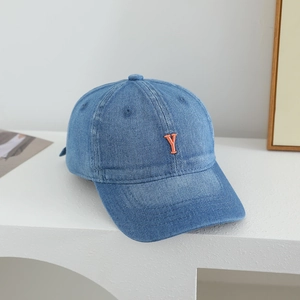 Detailed view of kids denim baseball cap featuring orange letter Y embroidery and washed fabric