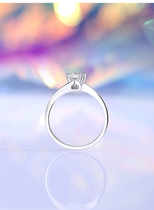 Macro shot of 925 silver moissanite ring with light bokeh and reflective surface