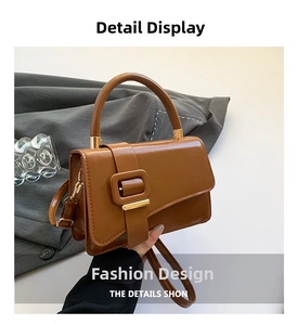 Detail view of caramel brown handbag with metal buckle and detachable shoulder strap