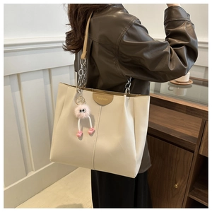 Borsa tote di moda con ciondolo mostro rosa indossata da modella in interni eleganti