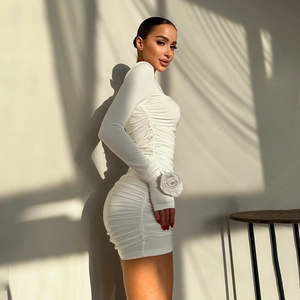 Detailed view of the 3D rose embellishment on the sleeve of this white ruched dress