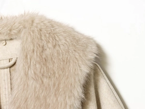 Detailaufnahme des eleganten Pelzkragens und des strukturierten Wollmantels