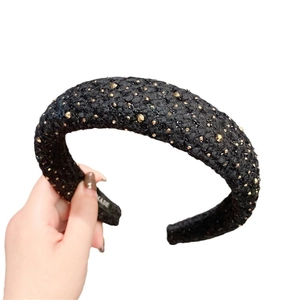 Padded black fabric headband with gold studs for a vintage retro hair accessory style