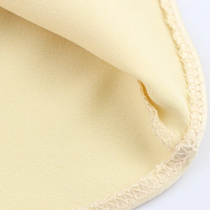 Makroansicht der hellgelben Seidenstoff-Textur mit sauberen Overlock-Nahtdetails