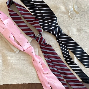 Close-up of heart print and striped satin scarves with woven texture background