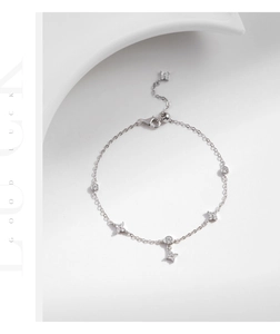 Detail view of s925 silver lucky clover bracelet with round zircon pendants on geometric background