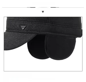 Detail of black winter military cap with earflaps and silver SP triangular metal logo