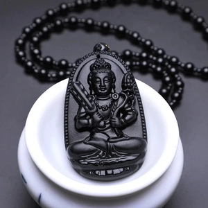 Polished black obsidian necklace with detailed Buddhist deity carving on lotus throne