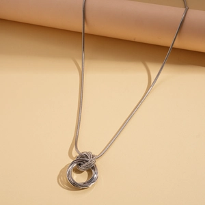 Detail view of interlocking silver circular pendants on a sleek snake chain necklace