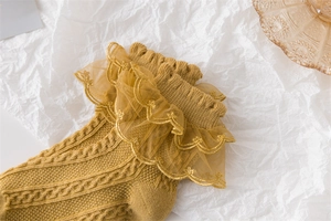 Detailed macro view of ginger yellow socks with cable knit and double layer lace trim