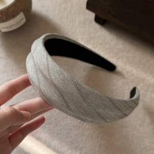 Detail shot of grey herringbone fabric headband with thick non-slip black lining texture