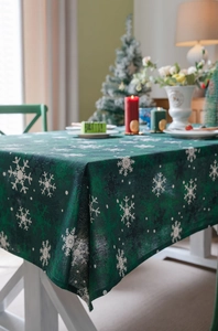 Détail macro de la nappe de Noël vert foncé avec motifs de flocons et texture du tissu