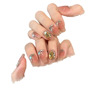French gradient pink press-on nails with amber gemstones and glitter in coffin shape