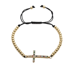 Détail du bracelet de perles dorées réglable avec croix et zircons multicolores