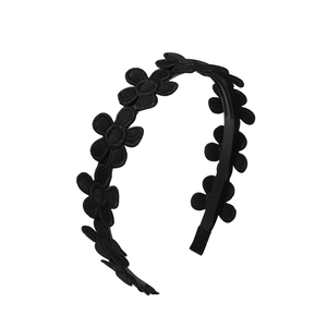Detail of black fabric daisy embroidery flowers on a classic vintage children headband