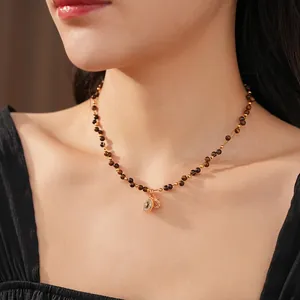 Tiger eye stone beaded necklace with double pendants on a female model's neck