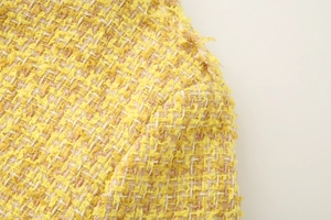 Macro-opname van gele tweed stof met goudkleurige metallic draden en textuur
