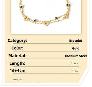 Detail of gold titanium steel layered bracelet with hollow heart and green star charm