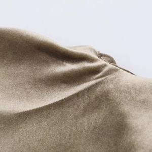 Detailed close-up of champagne velvet fabric with soft sheen and pleated texture