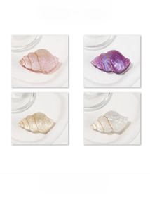 Close-up of shell-shaped hair claws in four colors with pearlescent finish and gold lines