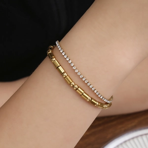 Elegant gold-tone double-layered Morse code bracelet with crystals on a model's wrist