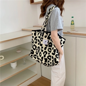 Lifestyle shot of woman carrying a large canvas tote bag with stylish leopard print pattern