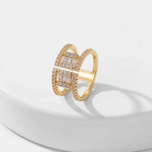 Golden double-layered square open ring with clear zircon stones on a white stand