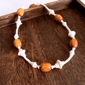 Detailed view of handmade wood beads and white resin spacers on vintage ethnic necklace