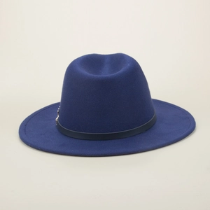 Detailed shot of navy wool fedora hat featuring a vintage gold metal leaf ornament