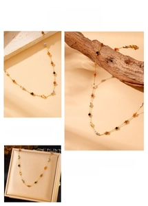 Detail of gold-plated stainless steel chain with colorful gemstone beads on natural props