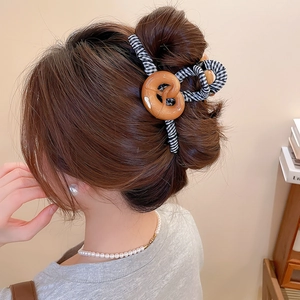 Gros plan d'une grande pince à cheveux en forme de bretzel avec tissu à carreaux vichy